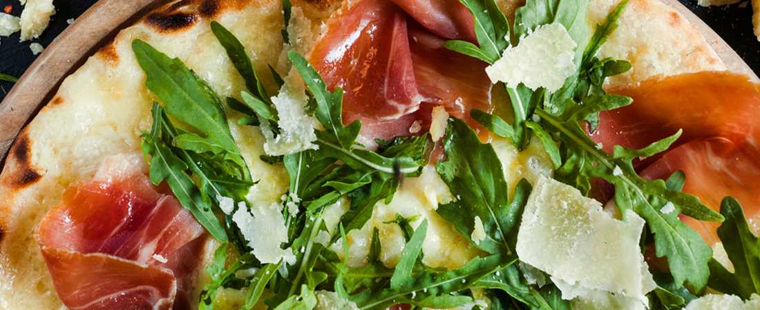 Pizza with procuito, arugula and parmesan